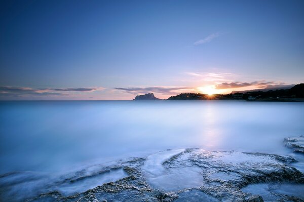 Le coucher du soleil et le bleu de la surface de la mer