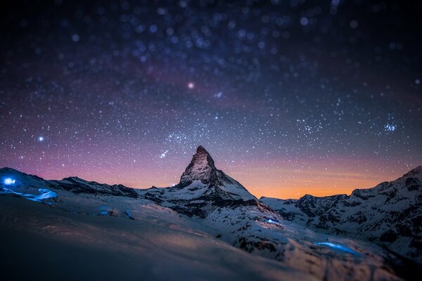 Cielo estrellado en la cima de los picos nevados