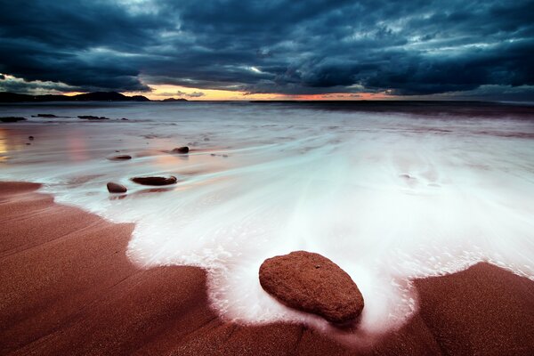 Schiuma di mare del mare al tramonto