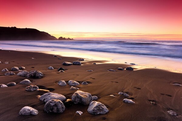 Puesta de sol costa del océano y piedras