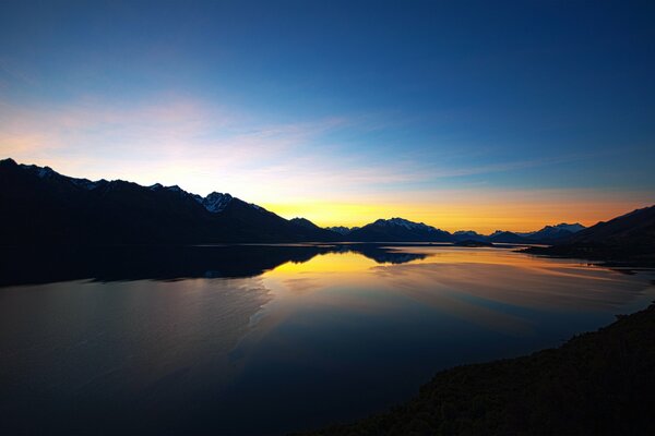 Il sole tramonta su un lago di montagna