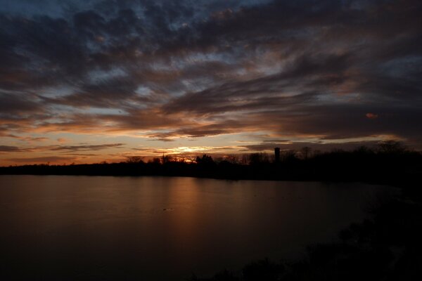 Wolken eines düsteren Sonnenuntergangs über dem Fluss