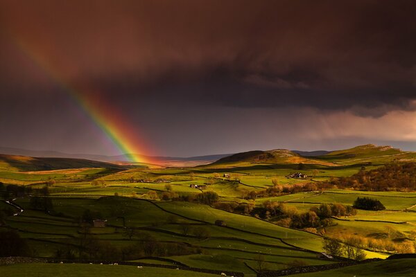 Arc-en-ciel dans le ciel et la colline verte