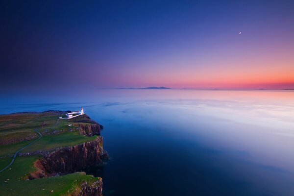 Phare sur un rocher au coucher du soleil semble mystérieux