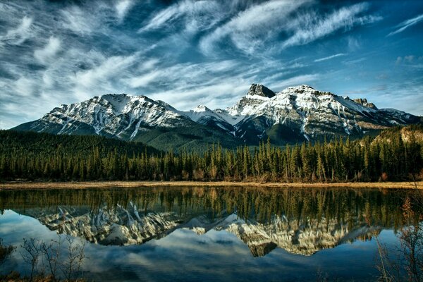 Reflet des montagnes et des nuages dans le lac bleu