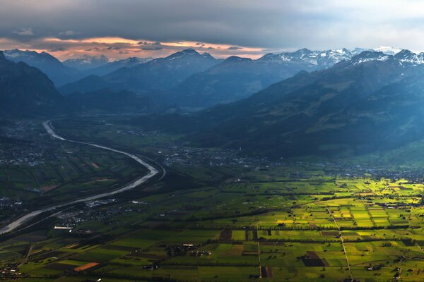 Vallée des montagnes près de la rivière au coucher du soleil