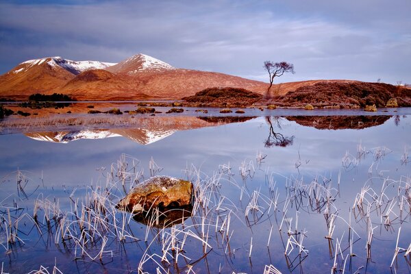 Rocky mountain hills on lake background