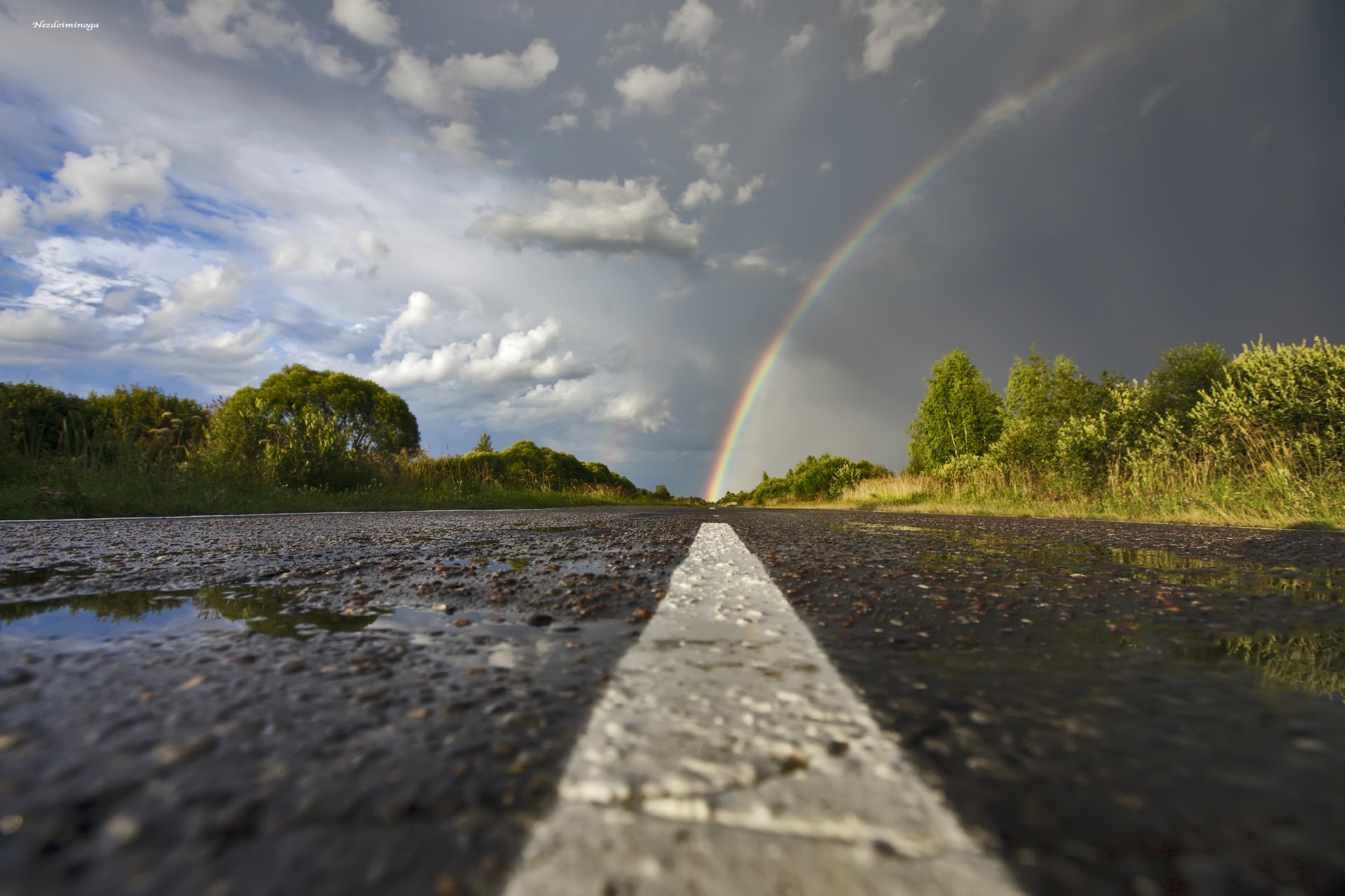 regenbogen straße asphalt pfützen nach regen himmel wolken bäume