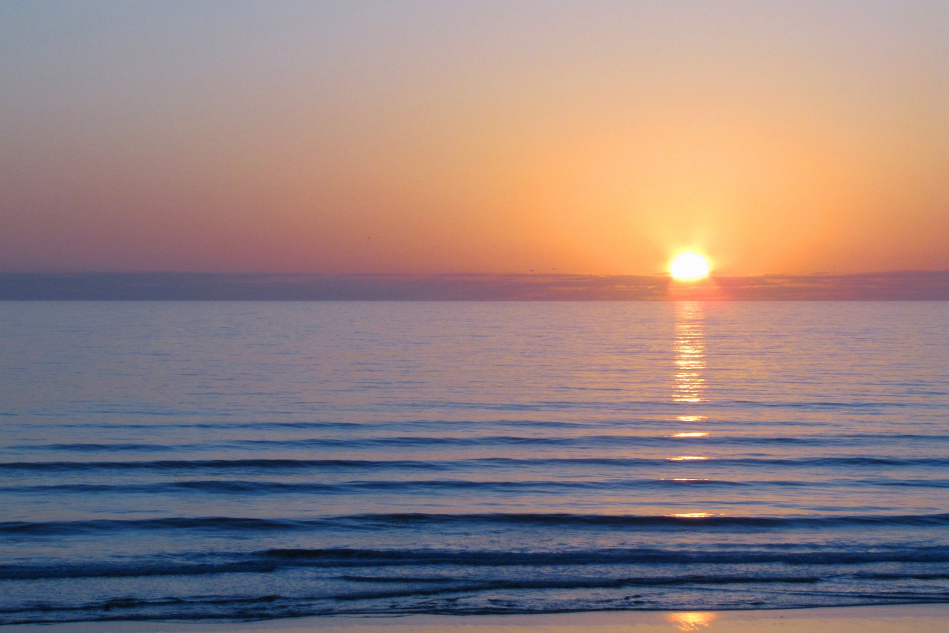 mare acqua superficie liscia onde colore alba mattina sole nuvole cielo luce paesaggio