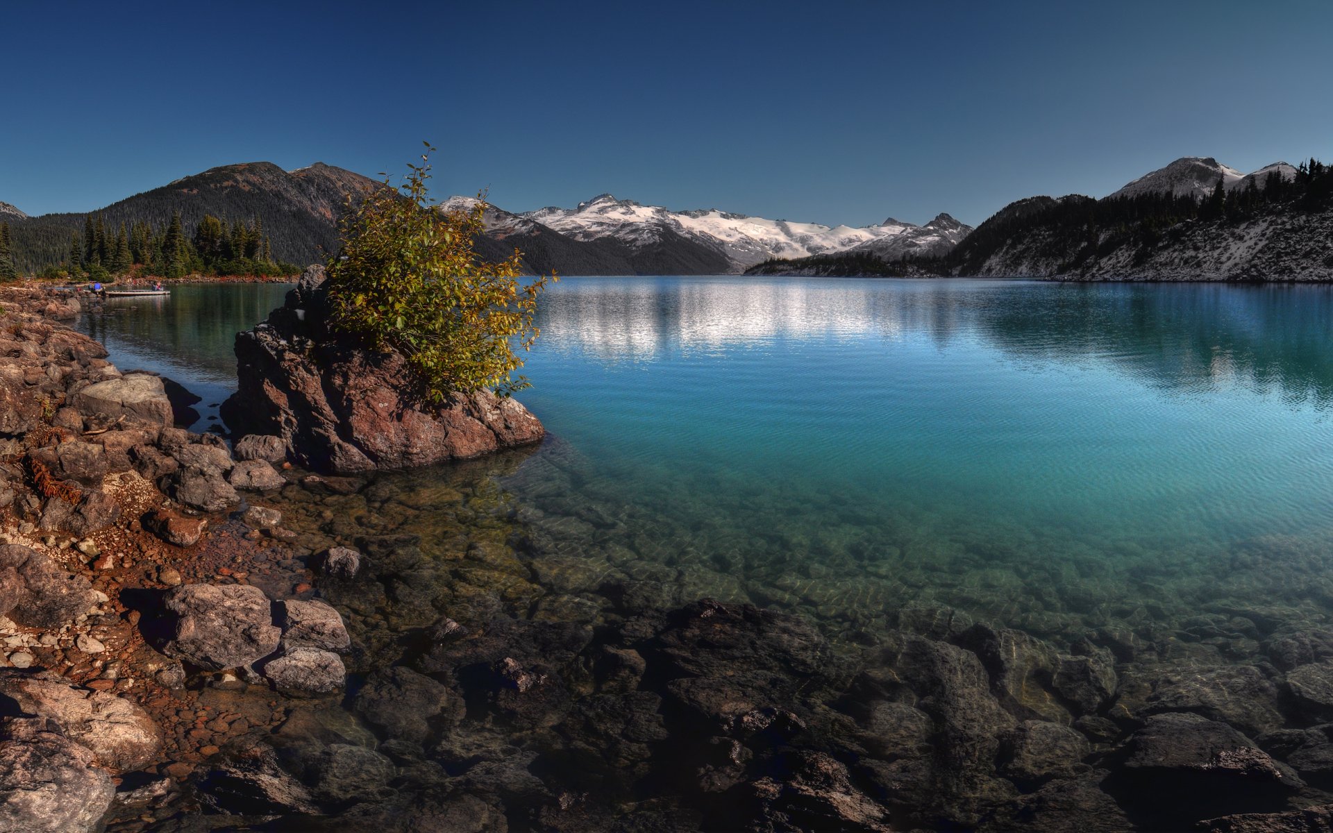 paysage ciel neige montagnes roches pente forêt arbres arbres de noël eau pierres lac garibaldi canada