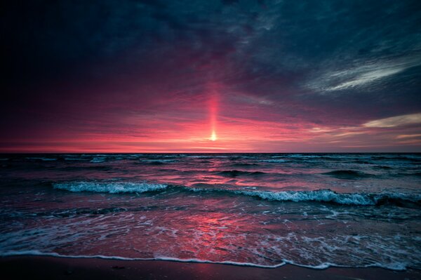 Coucher de soleil rouge dans les vagues de la mer