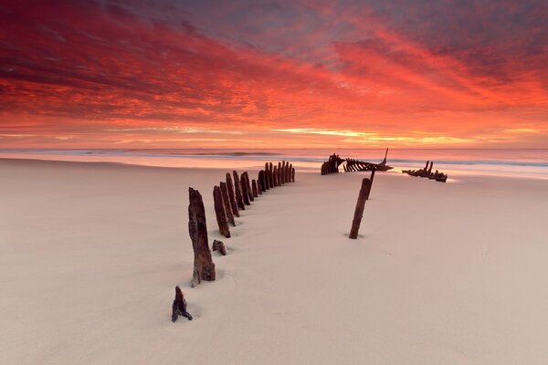 Sea beach at sunset with the remains of the ship