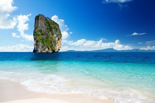 A lonely cliff on the background of the aquamarine ocean