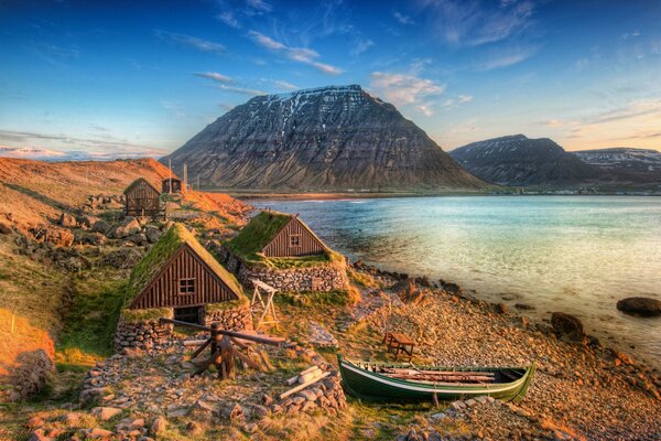 Maisons sur la côte de l Islande. Montagnes à l horizon