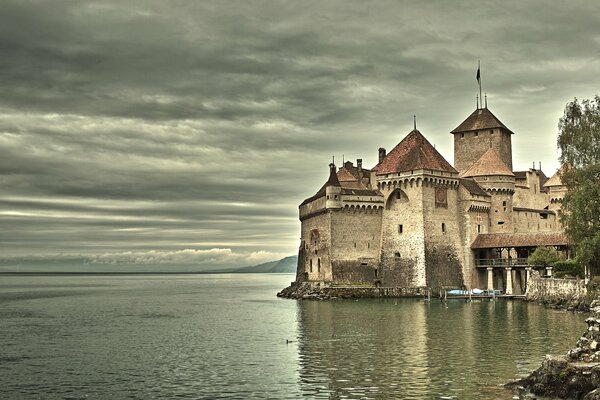 An old grey castle on a grey lake