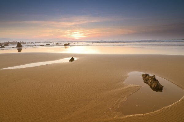 Deserted beach after low tide against the sunset sky