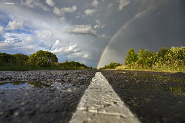 Nasser Asphalt und Regenbogen nach Regen