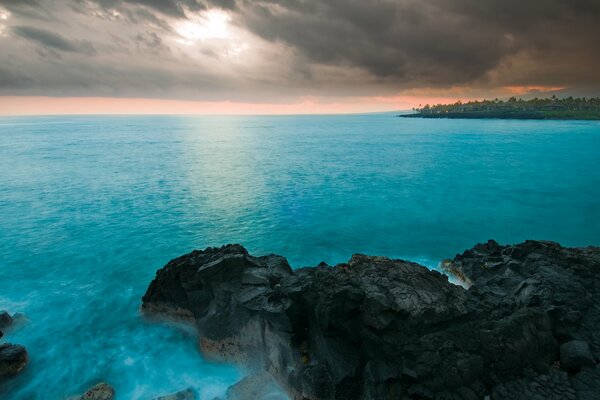 Sunset on the background of the sea and rocks