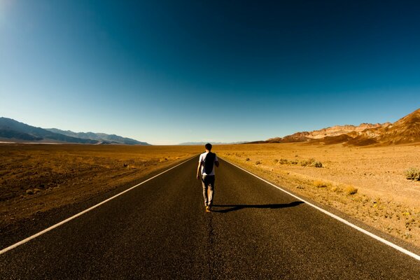 A man walks along a deserted road