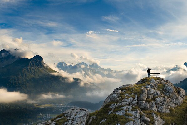 Panoramic picture of a man against the background of clouds and mountains