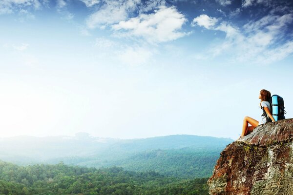 A girl traveler is sitting on a rock