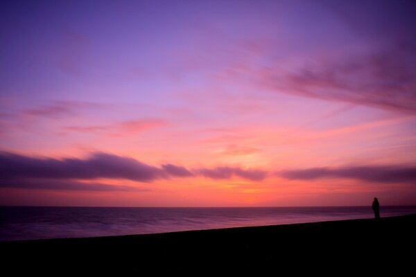 A girl on the coast in the evening by the sea