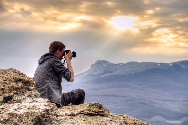 Ein Fotograf in der Höhe fotografiert Berge