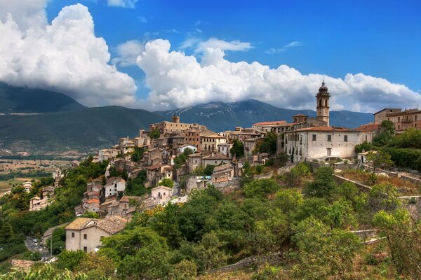 Château sur une montagne au milieu des maisons en Italie