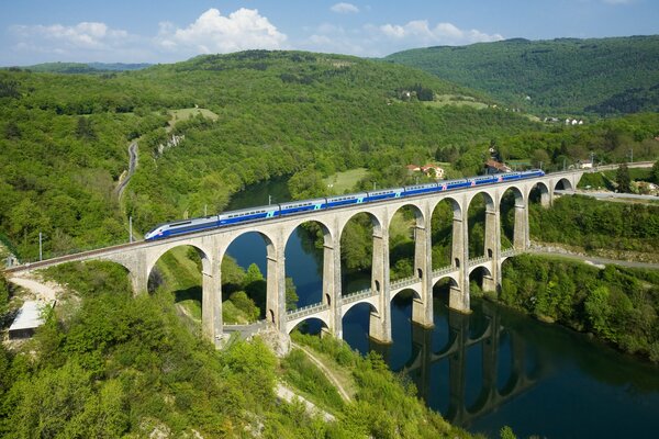 Blauer Zug rast über französische Brücke