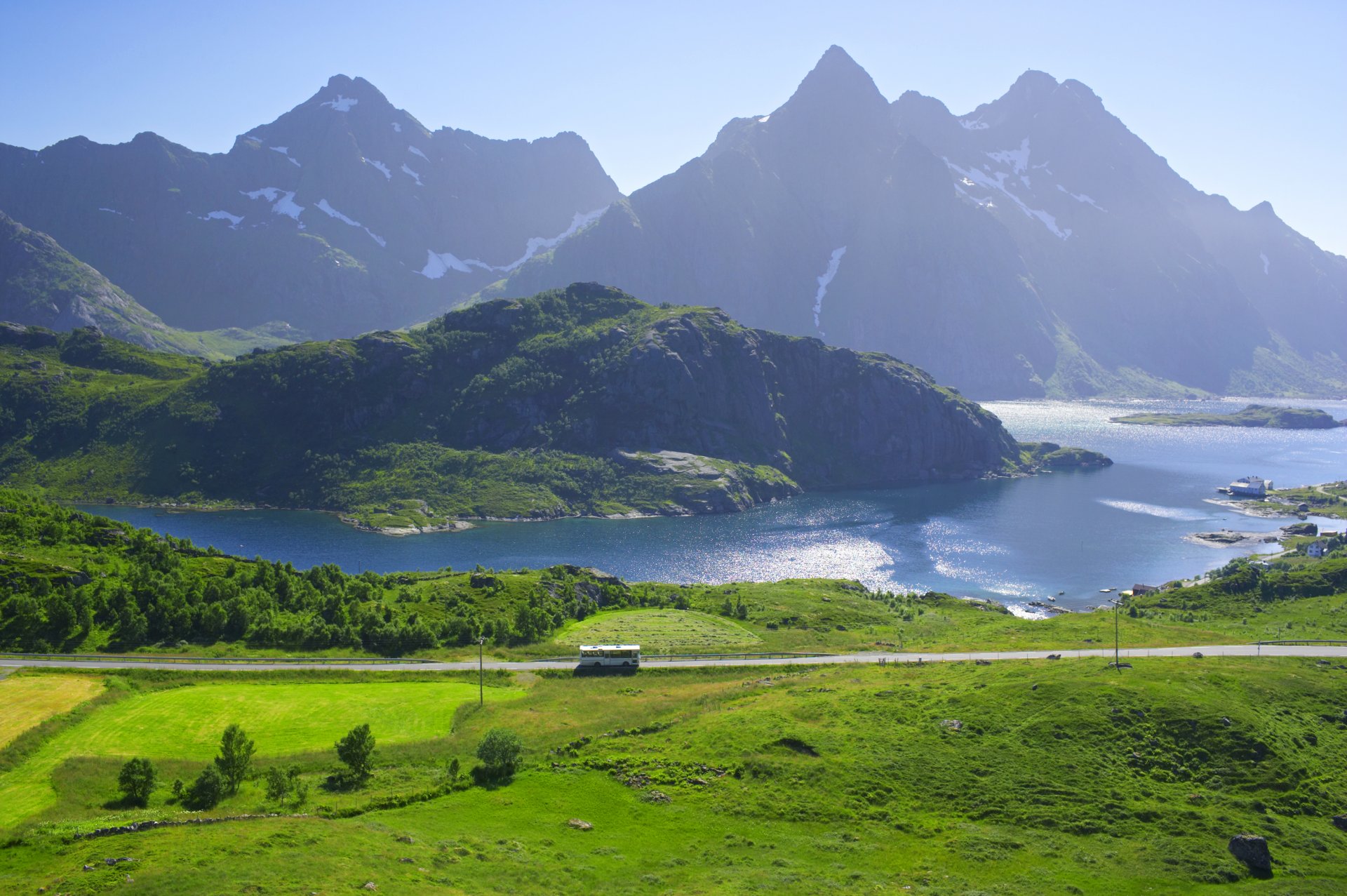 norwegen lofoten berge see ufer häuser felder straße bus