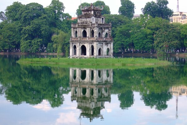 Edificio antiguo en la isla, reflejo en el agua