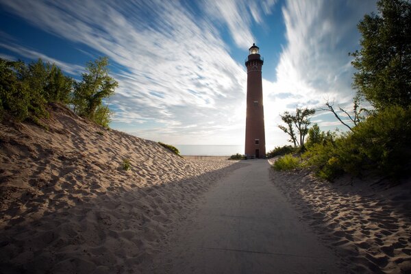 Sandy road to the lighthouse on the coast