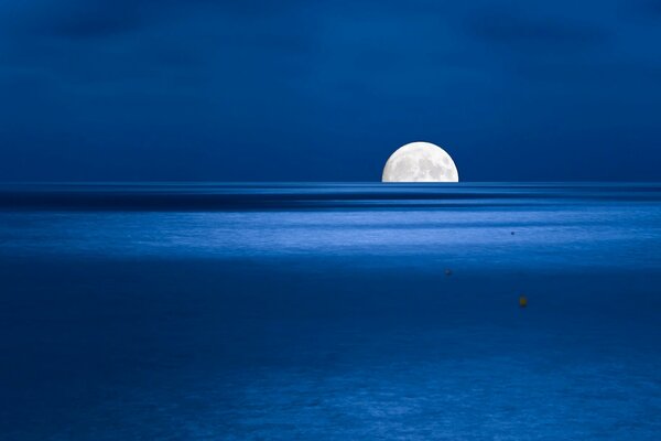 Media Luna en el horizonte sobre el mar