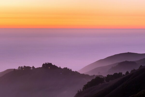 Contraste des collines violettes et du coucher de soleil orange