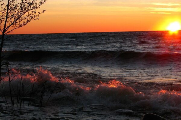 Salpicaduras de olas en el fondo de la puesta de sol