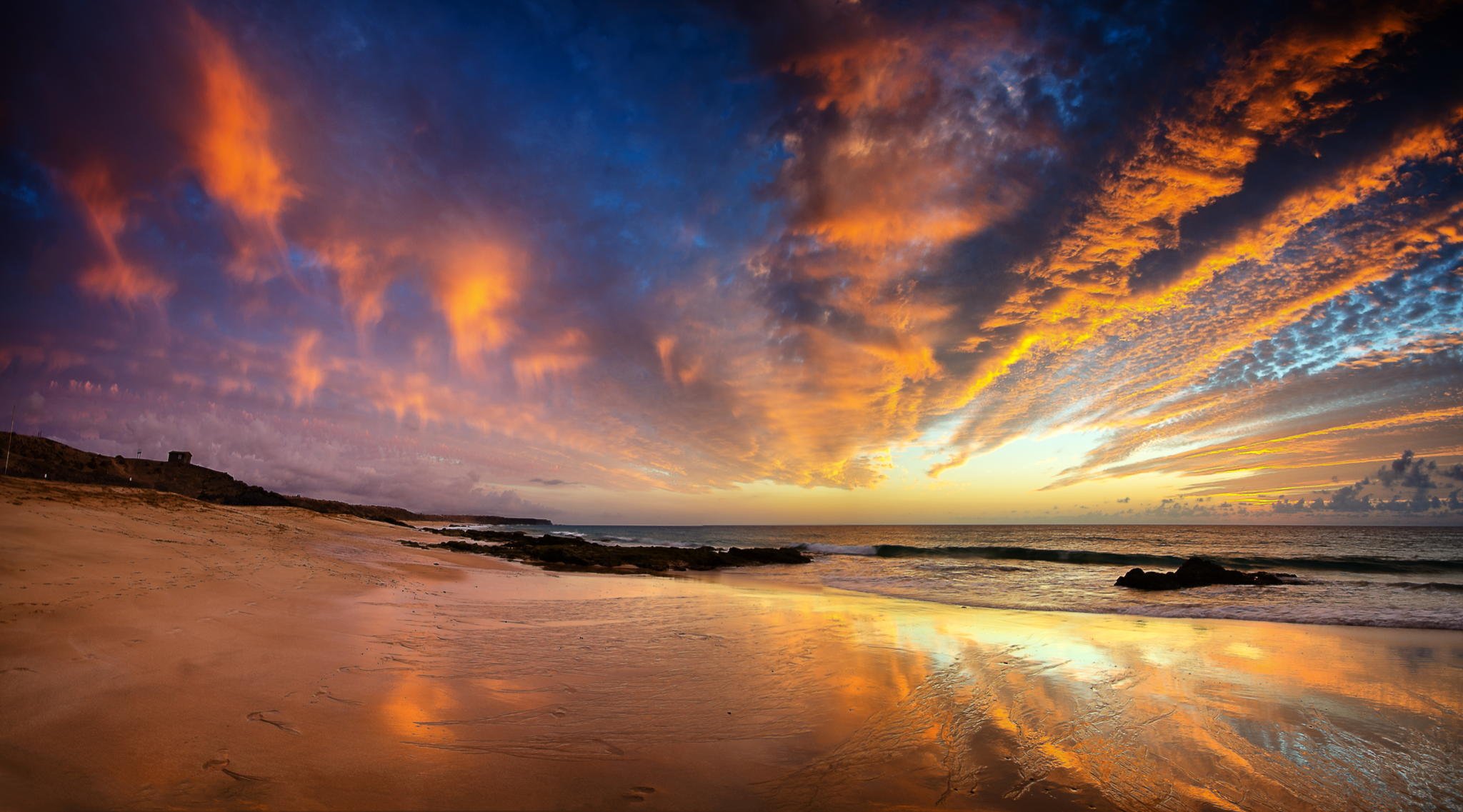 puesta de sol playa rocas océano arena