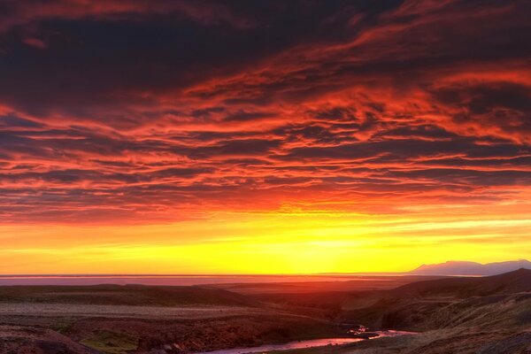 Sonnenuntergang in den Bergen neben dem Fluss