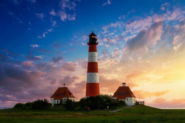 Faro y casas en el fondo del hermoso cielo al atardecer