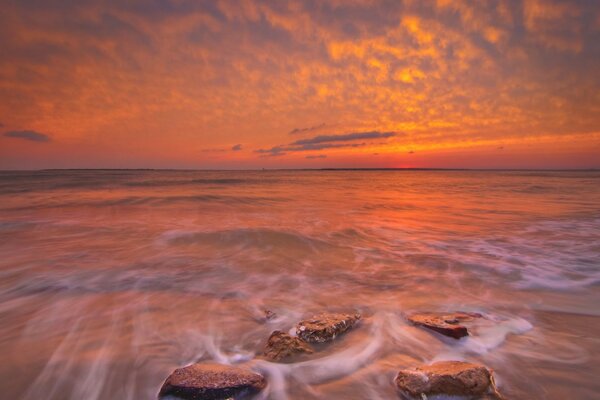 Heller Sonnenuntergang am Meer mit Steinen