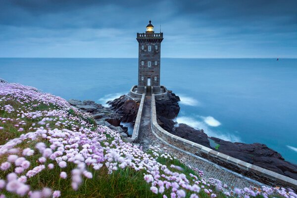 Faro en llamas en el crepúsculo del mar