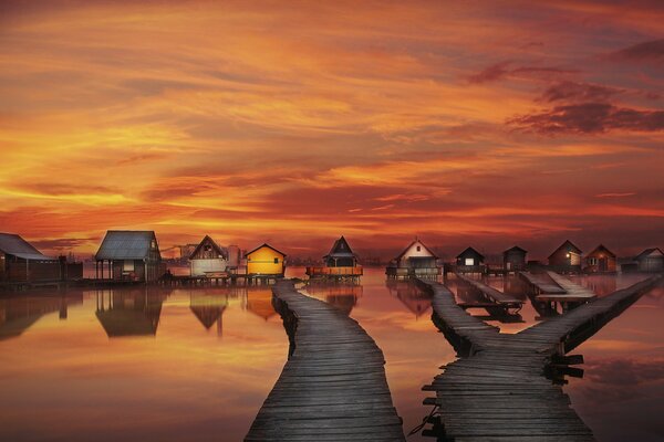 Casas en el mar con puentes en el fondo de hermosas nubes