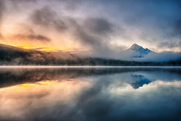 Lac brumeux matin sur fond de montagnes