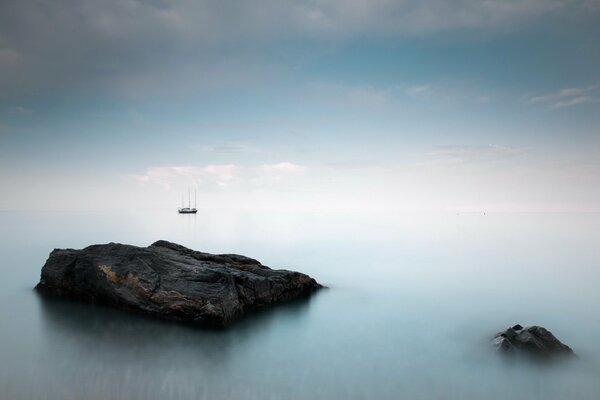 Landschaft mit Schiff am Meer im Nebel