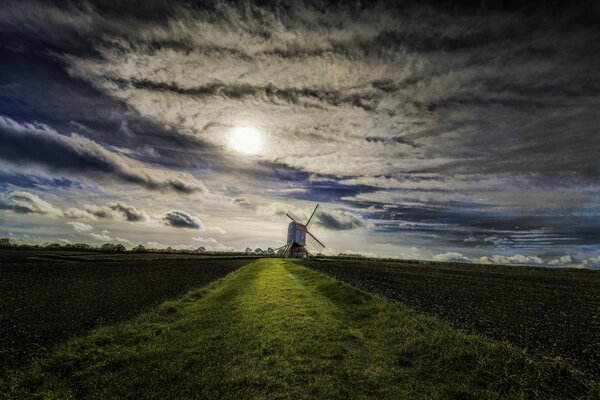 Champ avec moulin à vent sur fond de nuages chics