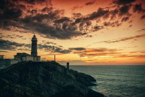 Lighthouse on the rock. Morning by the sea