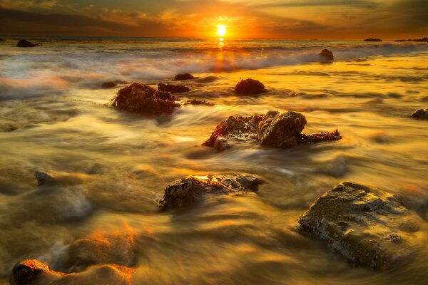 Puesta de sol en la playa de piedra de Malibu