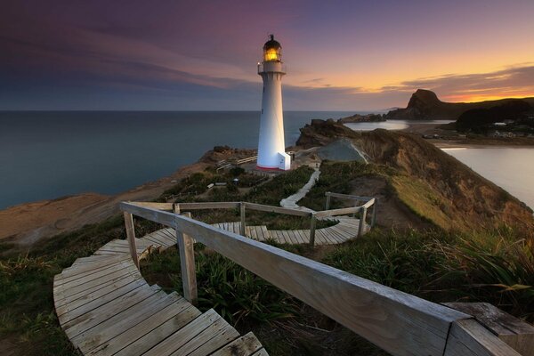 Faro a la luz de la puesta de sol iridiscente