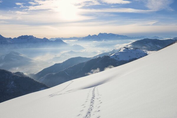 Massif montagneux enneigé d une altitude de. Beau paysage de montagne avec des traces d une moto sur une surface blanche