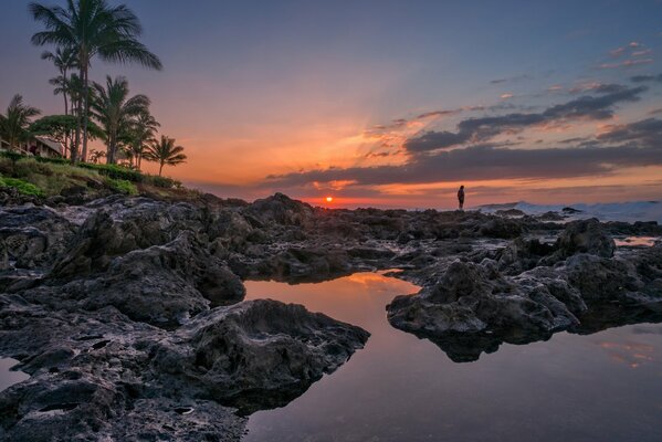 Puesta de sol en el fondo de una playa rocosa