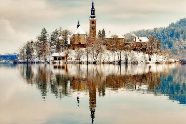 Die Kirche auf der Insel spiegelt sich im Winter im See wider